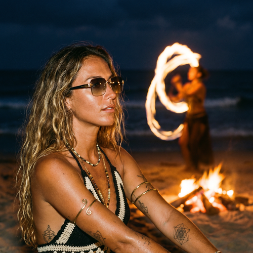 Rimless Gradient Luxe Sunglasses in Gold Grey worn at a beach fire-dance ceremony