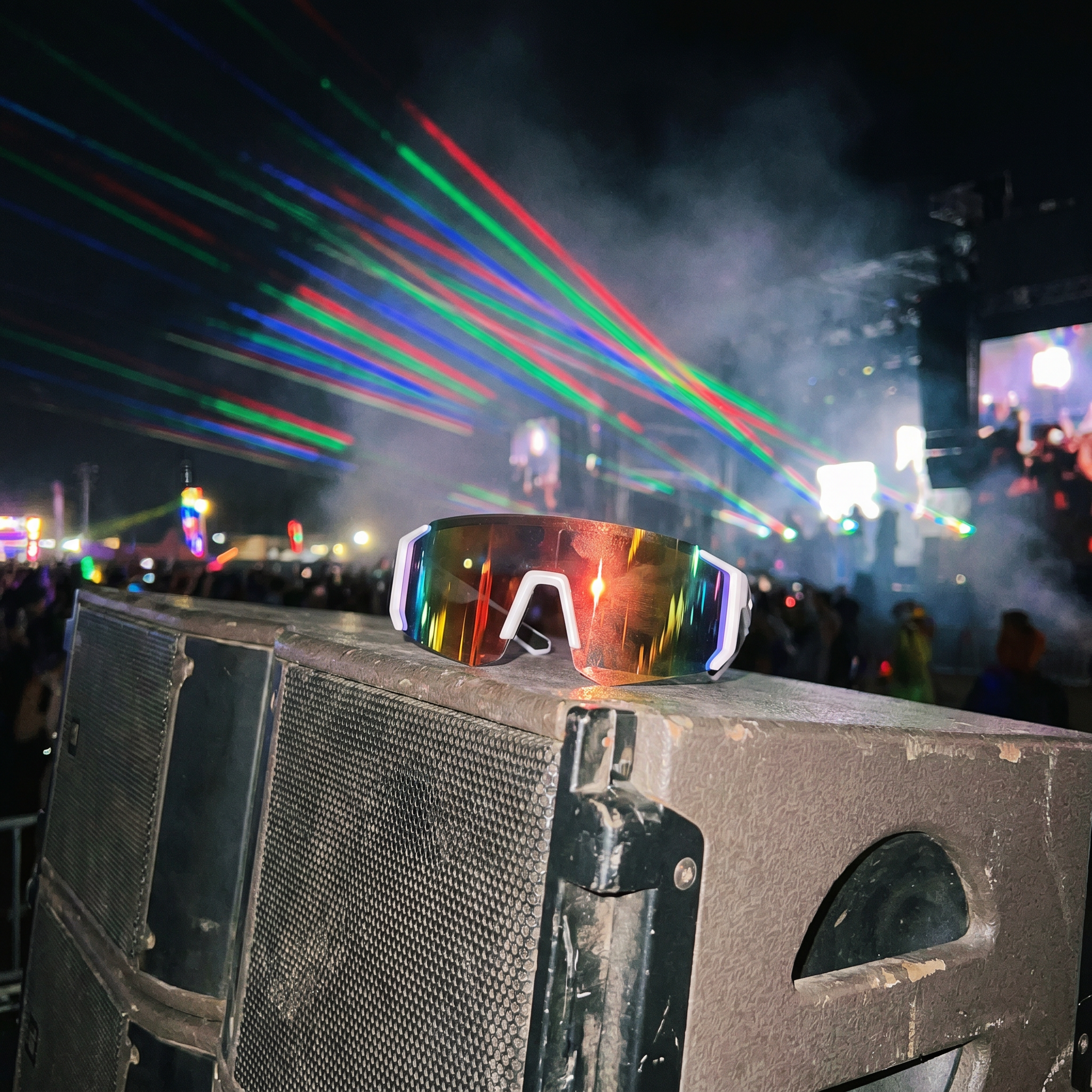 Swervy Blaze Shield wraparound sunglasses resting on a festival speaker stack with lasers